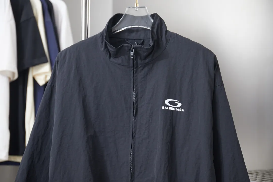 Balenciaga 𝘽𝘼𝙇𝙀𝙉𝘾𝙄𝘼𝙂𝘼 BLCG 26SS 71 front and rear half-circle letter embroidered sports suit Light luxury essential item for daily commuting for men and women Correct version Welcome to compare Detailed features · Customized matt Taslan jacket fabric · The fabric has undergone a waterproof coating process · The interior is made of three-grade polyester bird's eye mesh · OS ultra-loose silhouette design · Side zipper pockets Small stand-up collar design · Internal zipper pocket design · Elastic waistband design at the hem · Customized molded hardware zippers Jacket double puller design · Tajima high-speed embroidery machine with 100,000-needle three-dimensional design · Double side pockets on trousers · Original main mark washed tag brand packaging Color: Black/Milk Apricot Size: 46/48/50/52